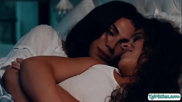 Shemale stepmom and her stepdaughter are on the bed having a good